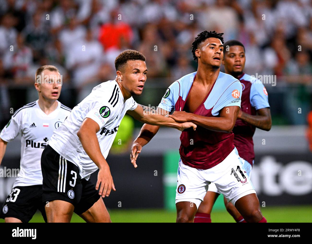 Legia Warsaw's Steve Kapuadi grabs onto Aston Villa's Ollie Watkins ...