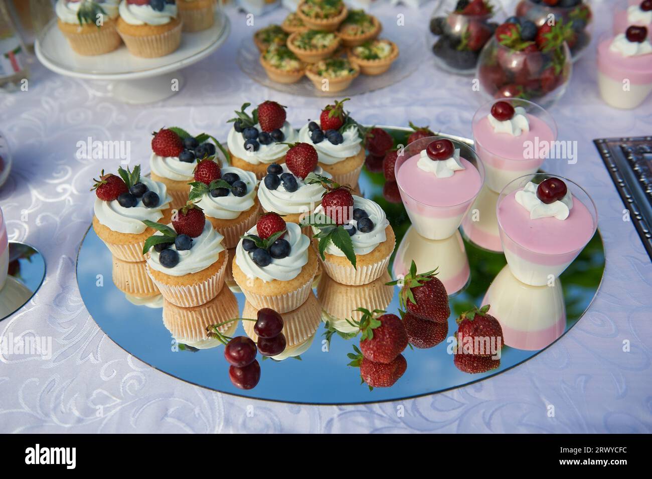 Delicious sweets of cupcakes with blueberry and strawberry on a welcome buffet table Stock Photo