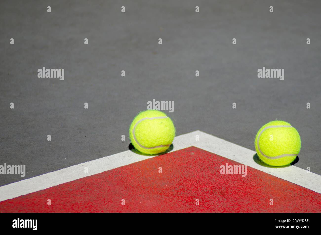 Two tennis ball in a red and gray tennis court Stock Photo Alamy