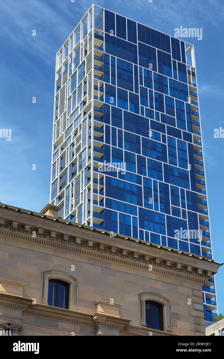 946 Blue glass facade of modern habitational building on Spring Street seen over the Old Treasury Building. Melbourne-Australia. Stock Photo