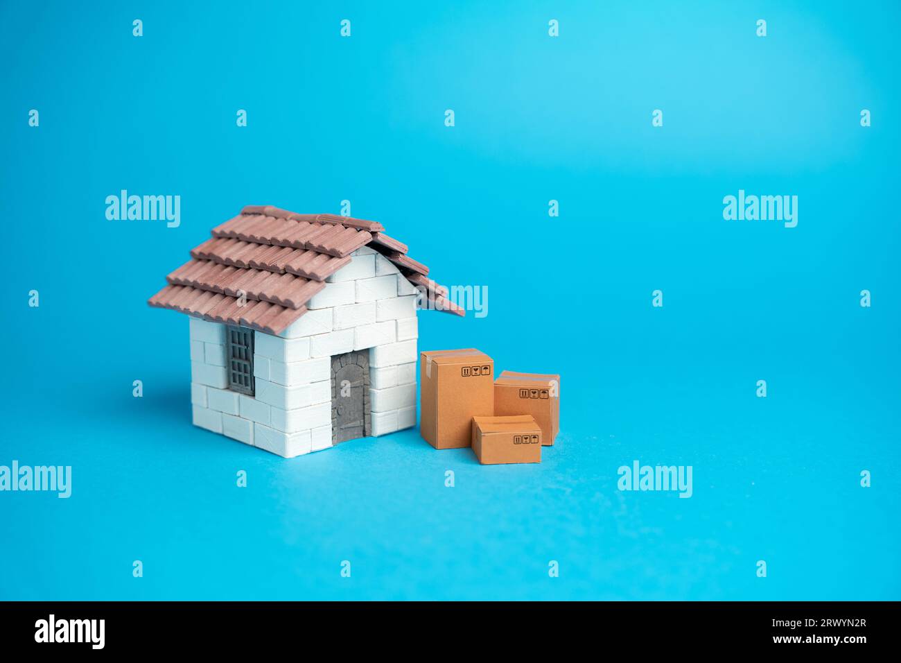 House and cardboard boxes. Home moving. Delivery of online orders. Stock Photo