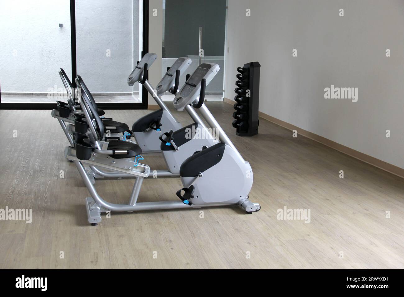 Black and white electric stationary recumbent bike in a gym for cardio, toning legs, burning 