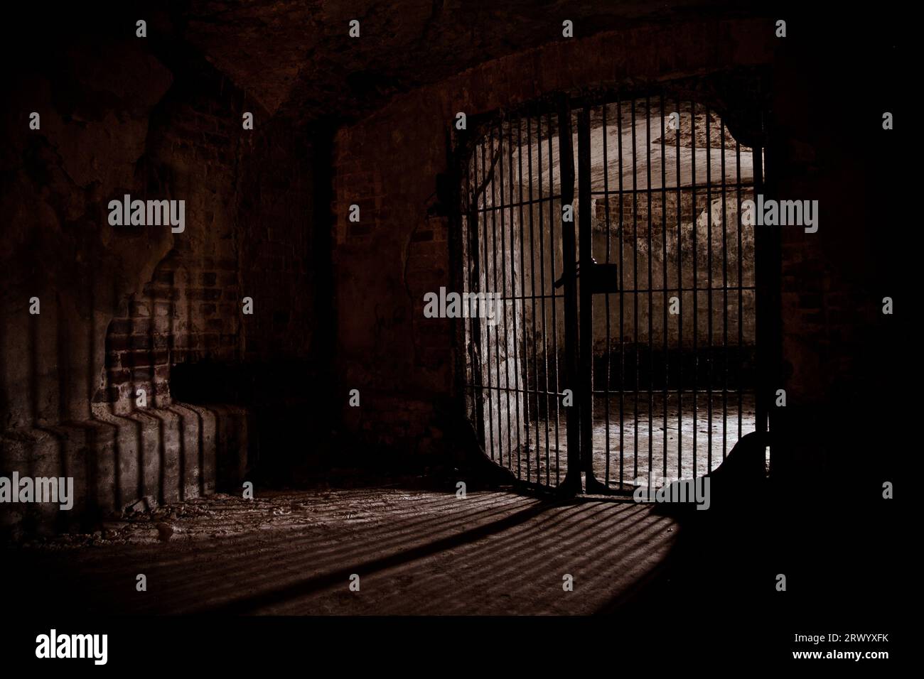 Light glowing from Iron grate in old cellar. Stock Photo