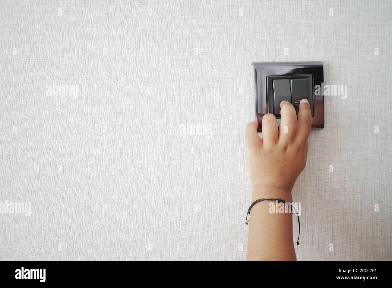 child finger turning on lighting switch with copyspace  Stock Photo