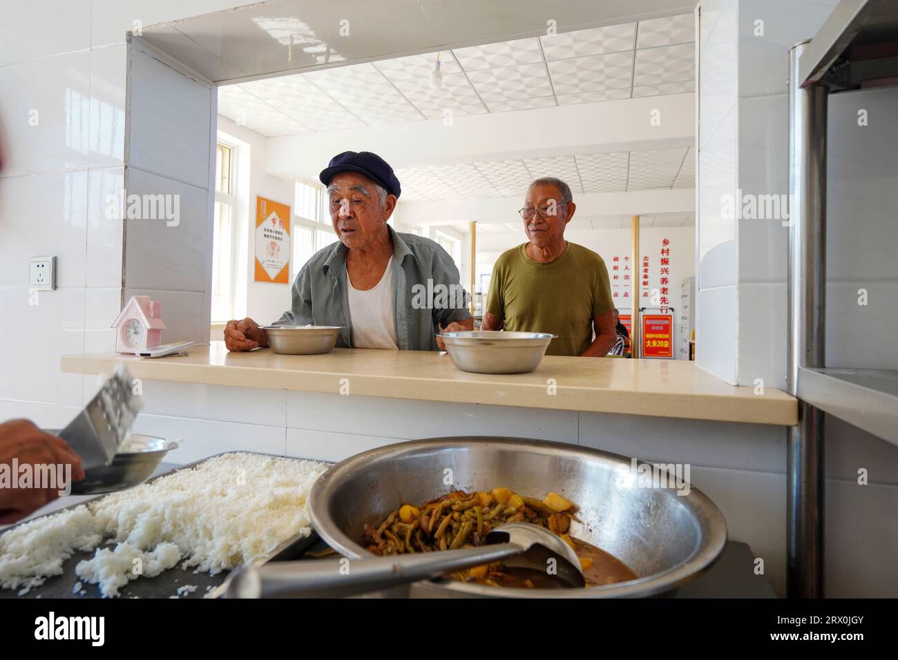 Luannan County, China - September 1, 2022: The elderly living alone are waiting for dinner in a small cafeteria. Stock Photo