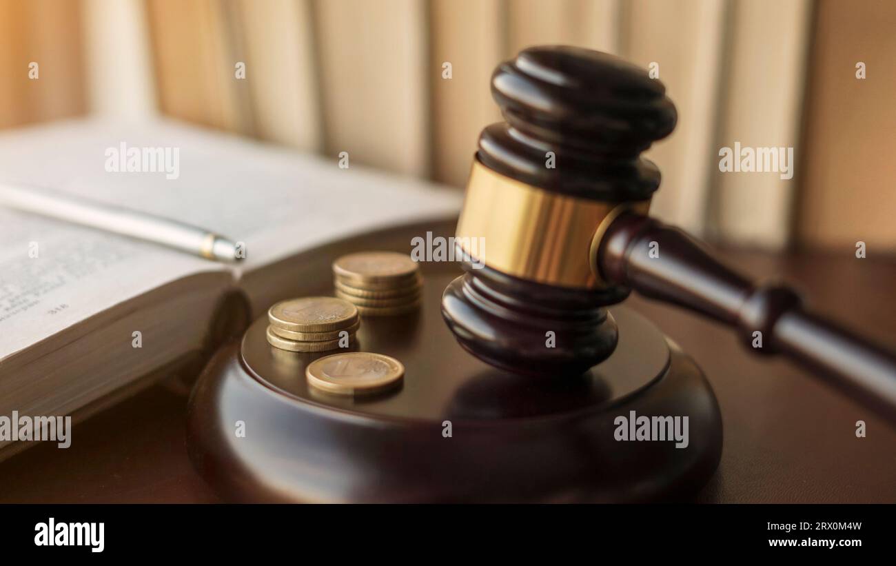 Judge gavel and Euro coins at court. Mallet of a judge deciding on financial corruption and tax fraud. Selective focus on the rings. Stock Photo