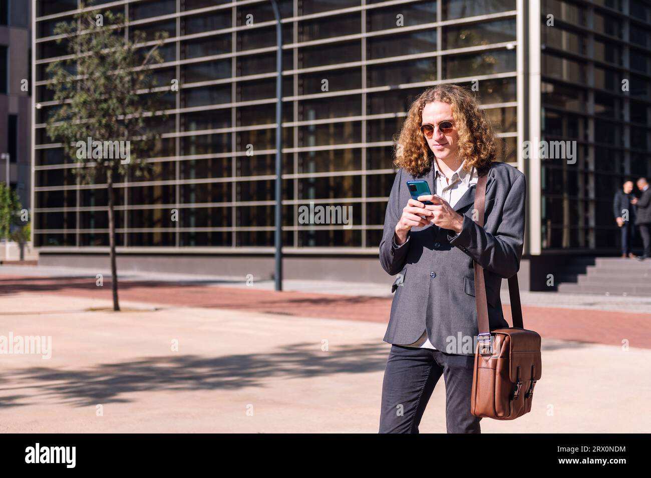 smiling young business man using mobile phone Stock Photo