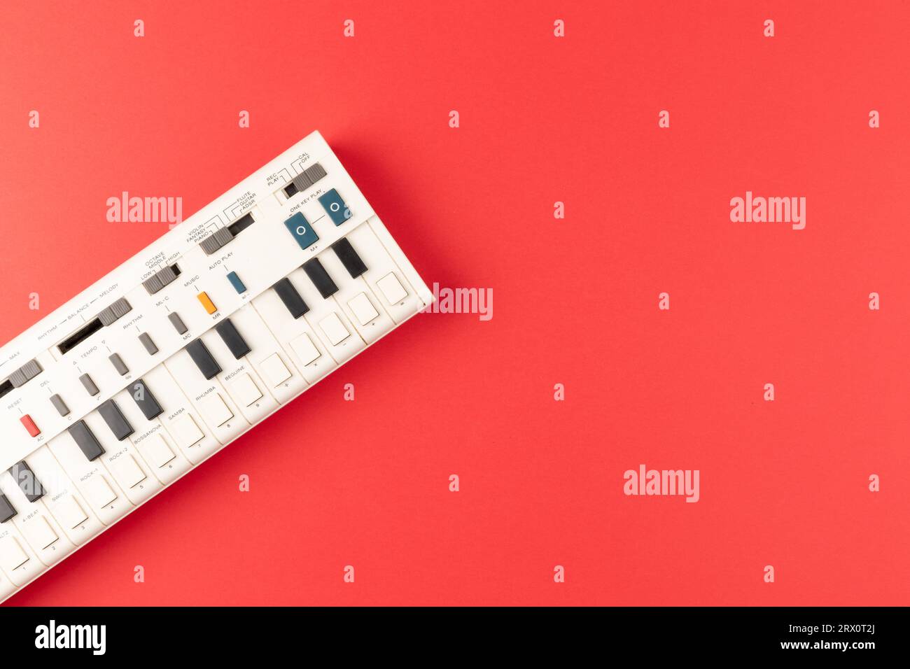 Vintage electronic keyboard synth piano on red background Stock