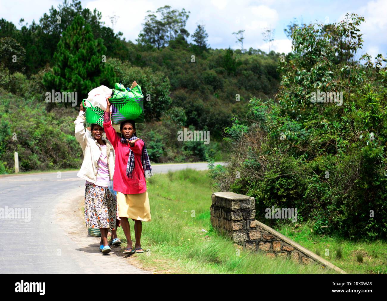 Malagasy women carrying baskets on their head. Stock Photo