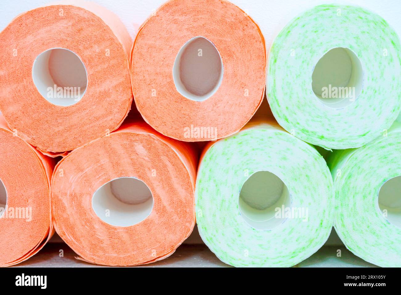 Different types of toilet paper background. Rolls of two colors. Rows of Toilet Coils close up. Stock Photo