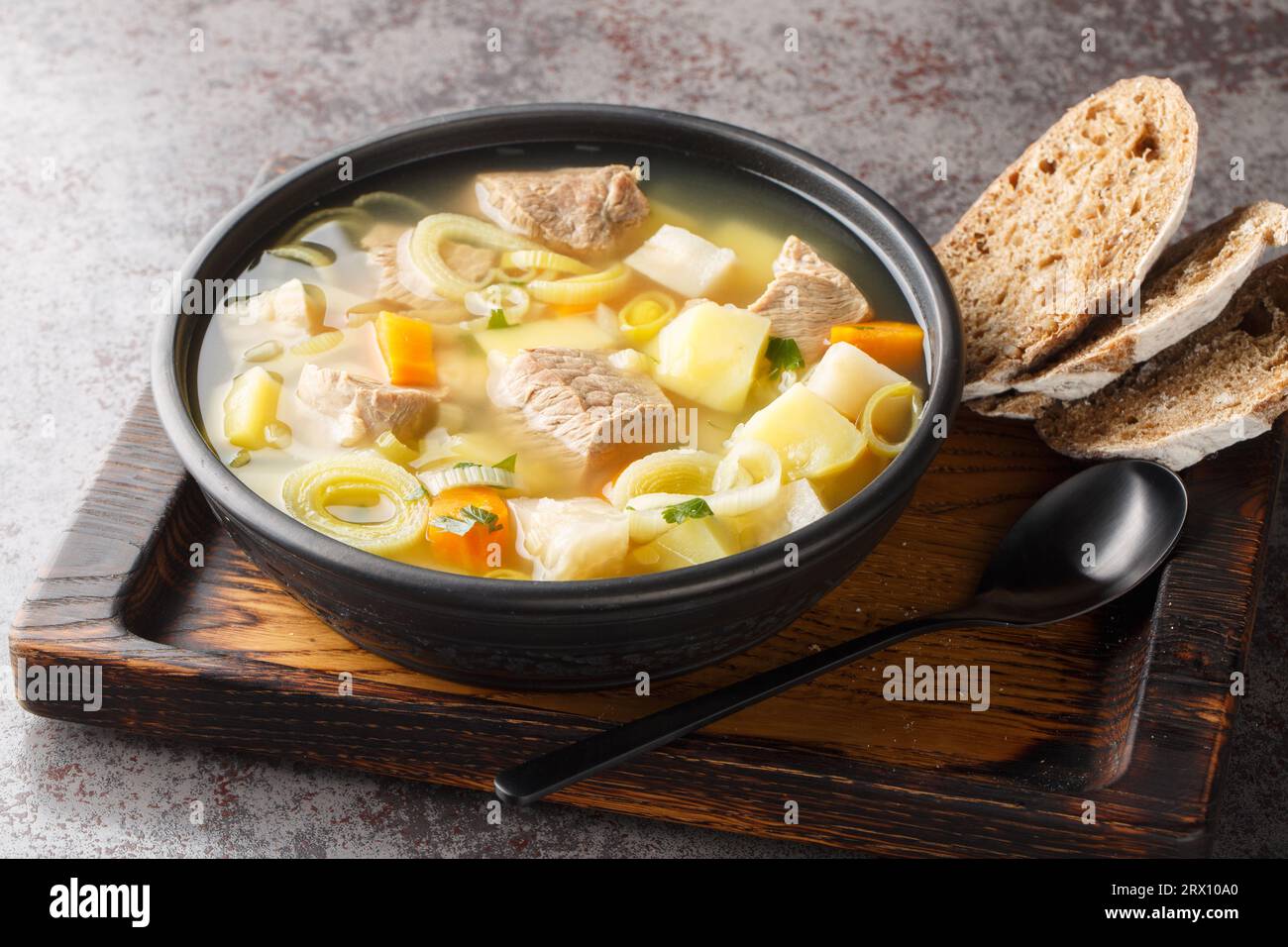 Kottsoppa soup is a meat and root vegetables include carrot, potato, celeriac, parsnip, turnip and Rutabaga close-up on a plate on the table. Horizont Stock Photo