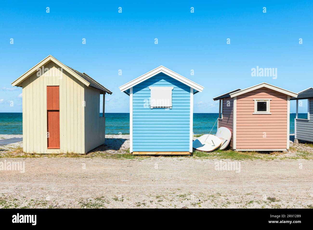 Colourful, windswept wooden bathing huts in the sand dunes on the beach of Skanör med Falsterbo on the Öresund in the morning sun, Skåne, Sweden Stock Photo