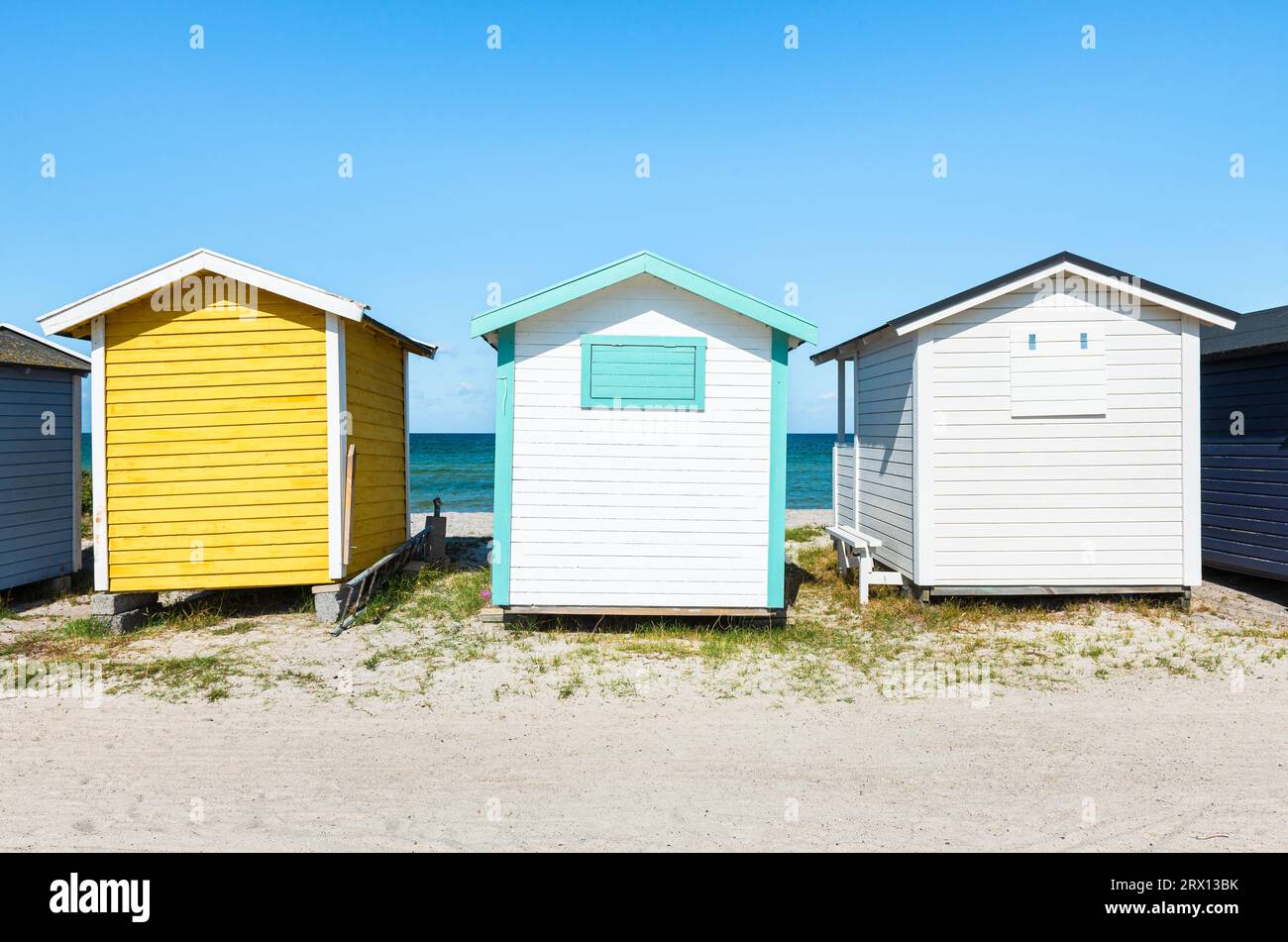 Colourful, windswept wooden bathing huts in the sand dunes on the beach of Skanör med Falsterbo on the Öresund in the morning sun, Skåne, Sweden Stock Photo