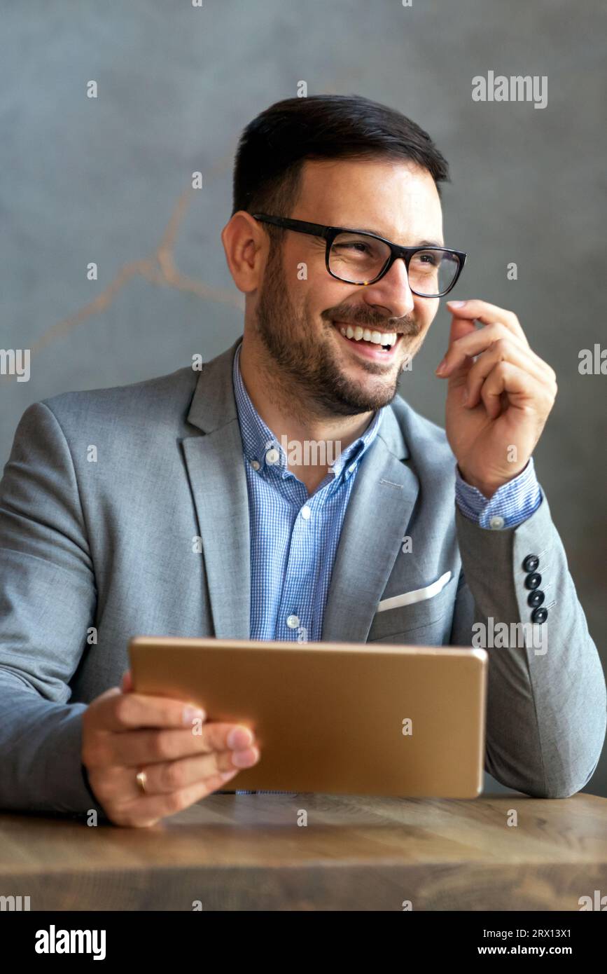 Portrait of happy succeffsul young business man, leader, ceo, manager using digital tablet to work. Stock Photo