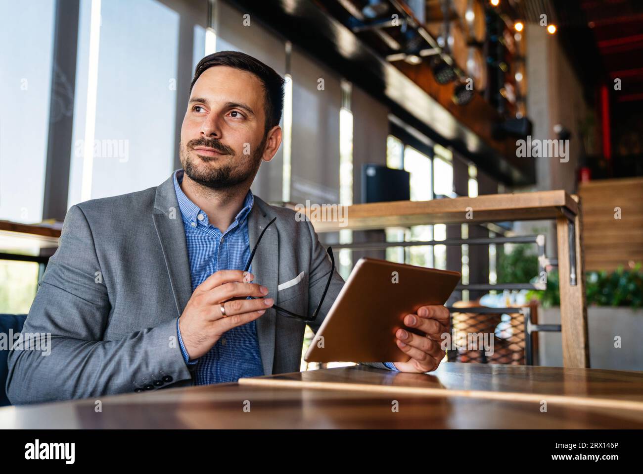 Portrait of happy succeffsul young business man, leader, ceo, manager using digital tablet to work. Stock Photo