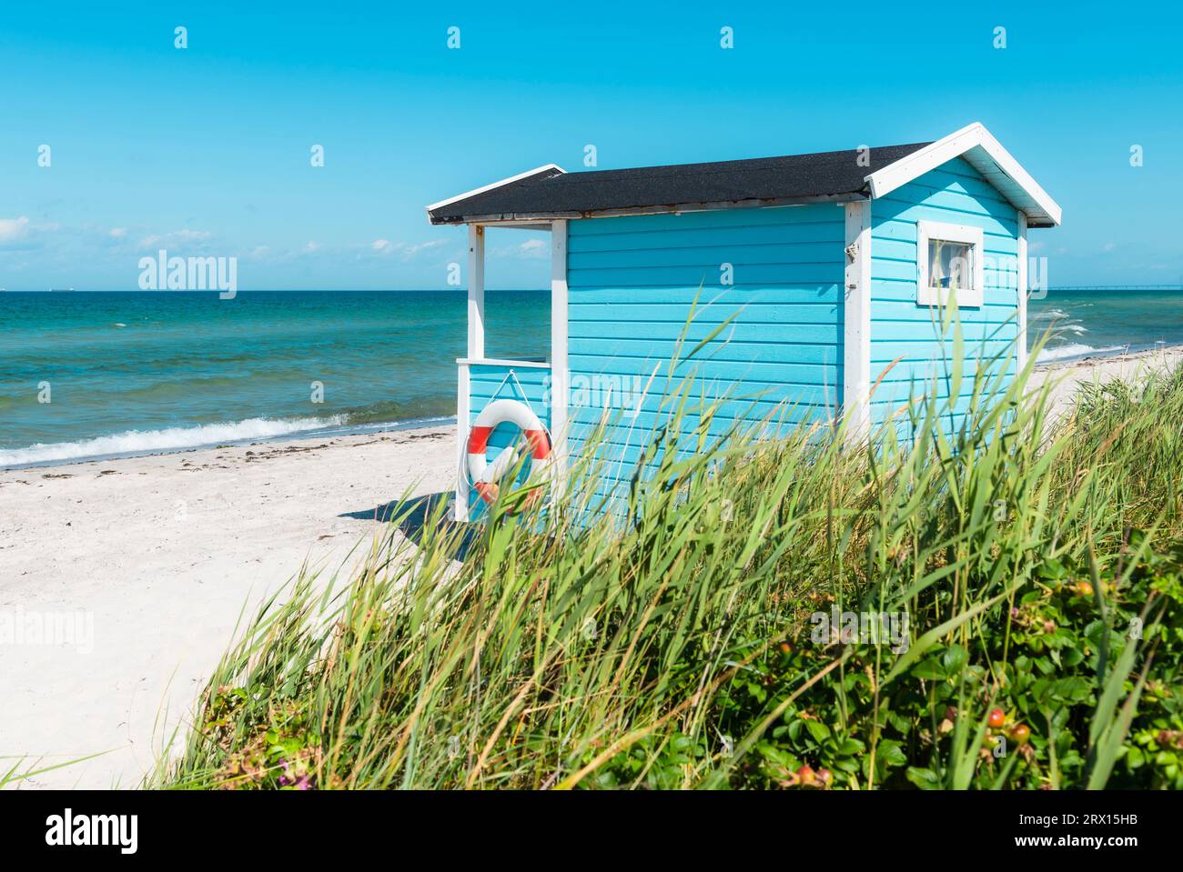 Blue and white wooden bathing hut on the beach of Skanör med Falsterbo at the Öresund in the morning sun, Skåne, Sweden Stock Photo
