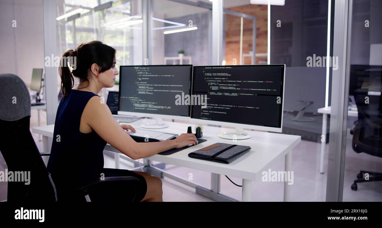 Programmer Woman Coding On Multiple Computer Screens Stock Photo - Alamy