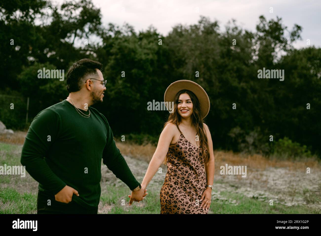 Couple walking holding hands at the park Stock Photo - Alamy