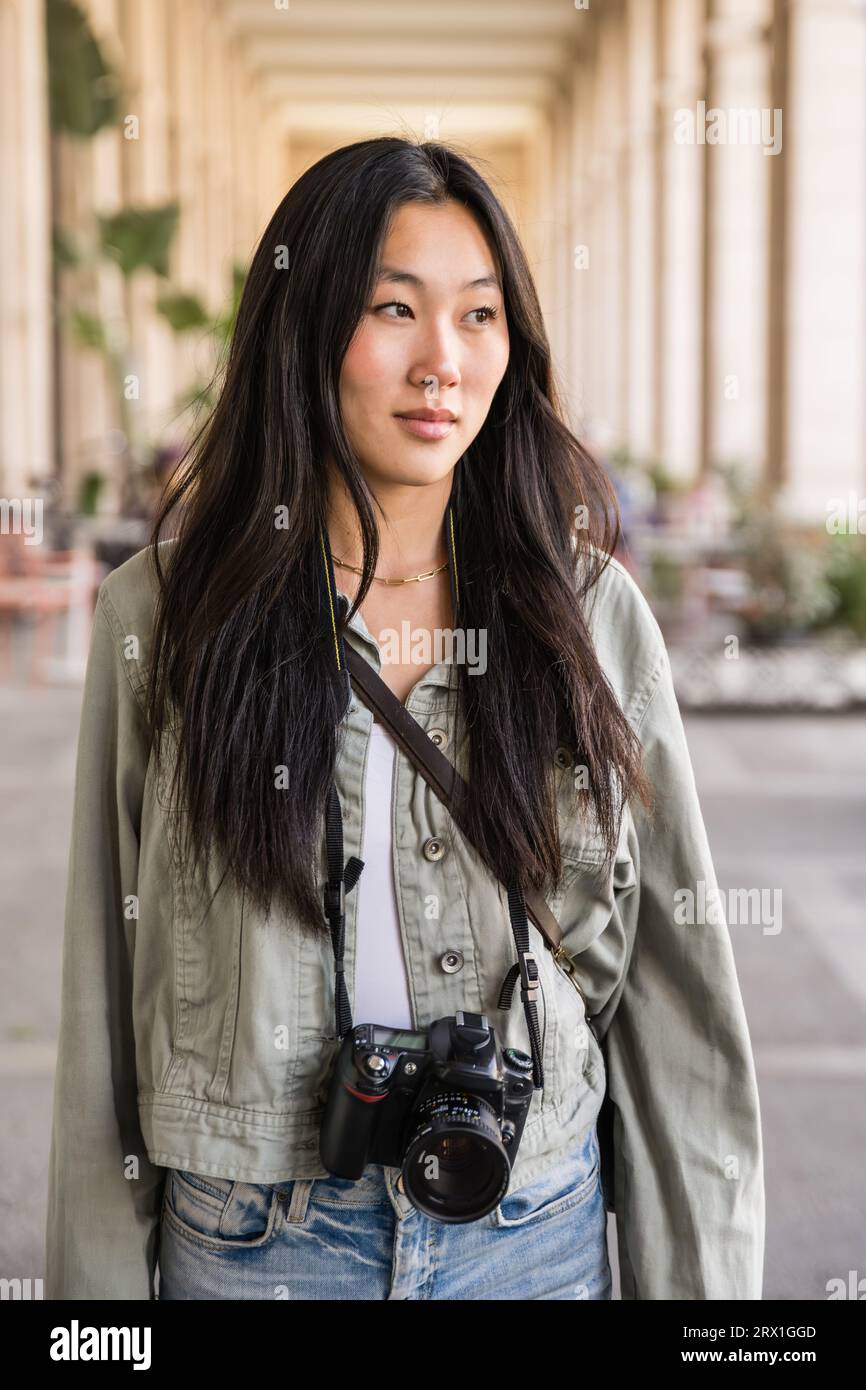 Handsome confident lady standing in the street with a photo camera. Stock Photo