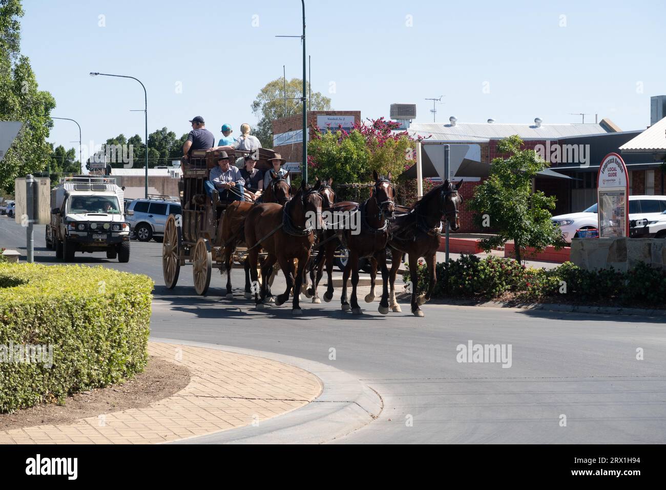 an old Cobb and Co stage coach lead by horses travel down main street of Longreach in western Queensland, Austraia Stock Photo