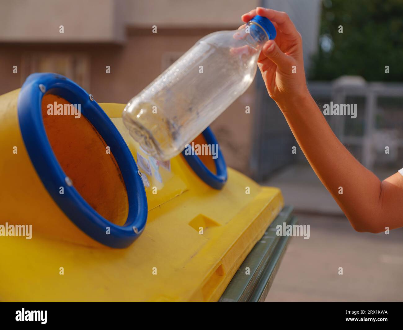 woman throwing plastic bottle Recycling bin stand on european street ...