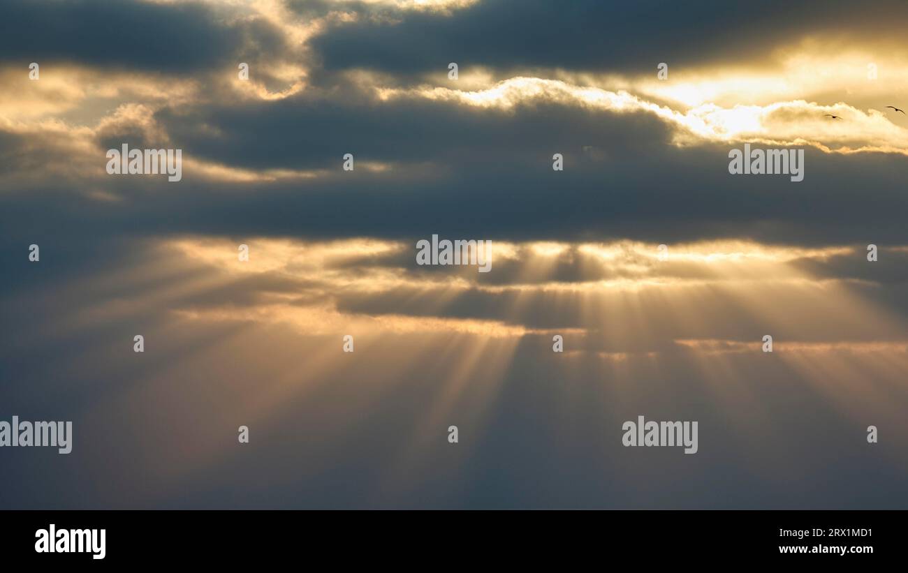 Sunbeams shining through clouds, gap in clouds, dramatic evening sky, Algarve, Portugal Stock Photo