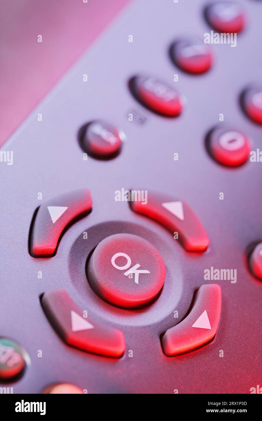 Digital television remote control buttons in red light Stock Photo