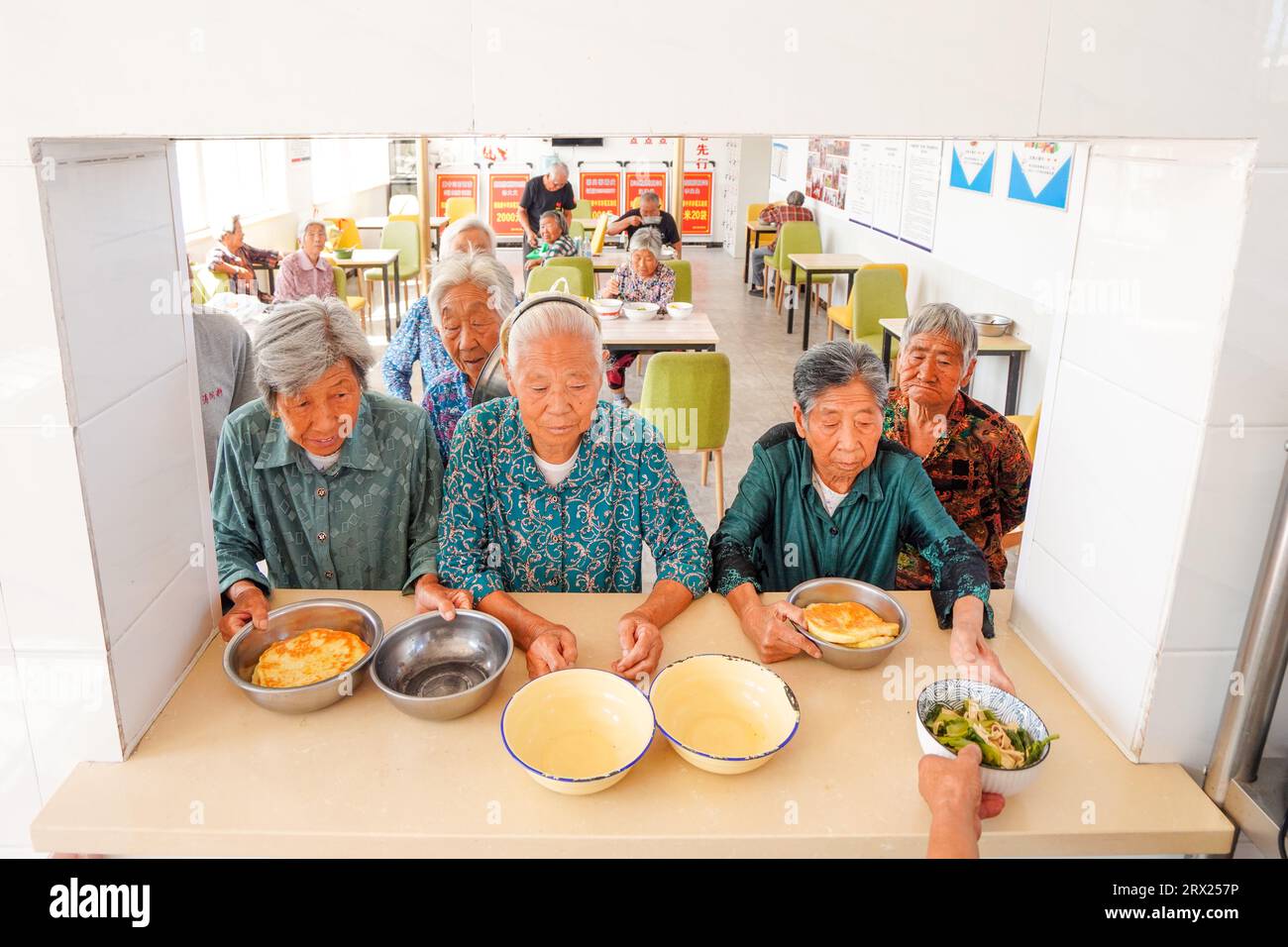 Luannan County, China - September 6, 2022: The elderly living alone are waiting for dinner in a small cafeteria. Stock Photo