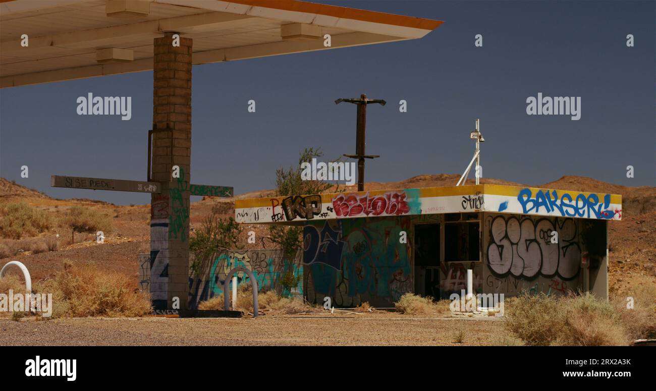 Vandalized shell of an abandoned gas station and overhead canopy. Stock Photo