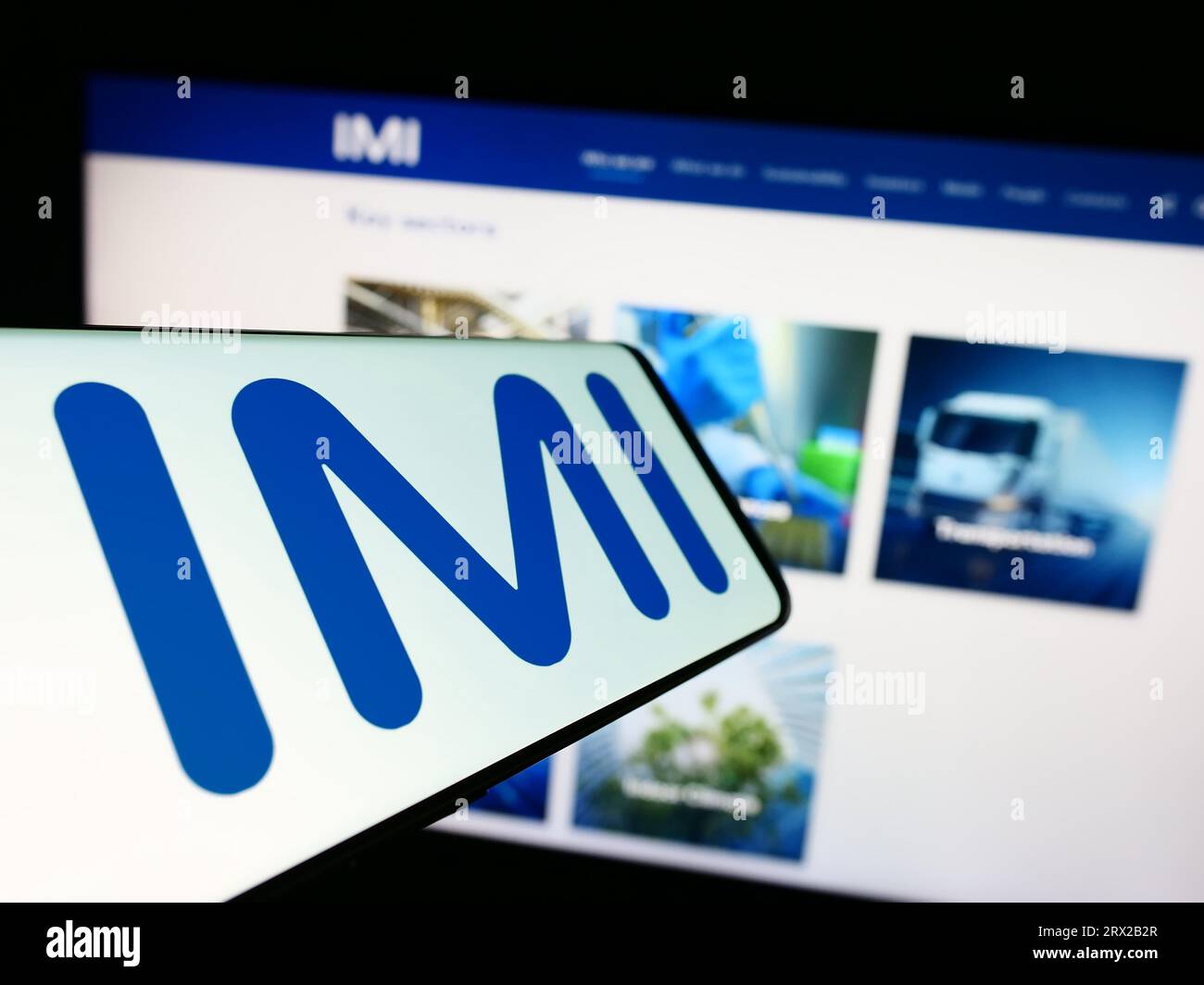 Cellphone with logo of British engineering company IMI plc on screen in front of business website. Focus on center of phone display. Stock Photo