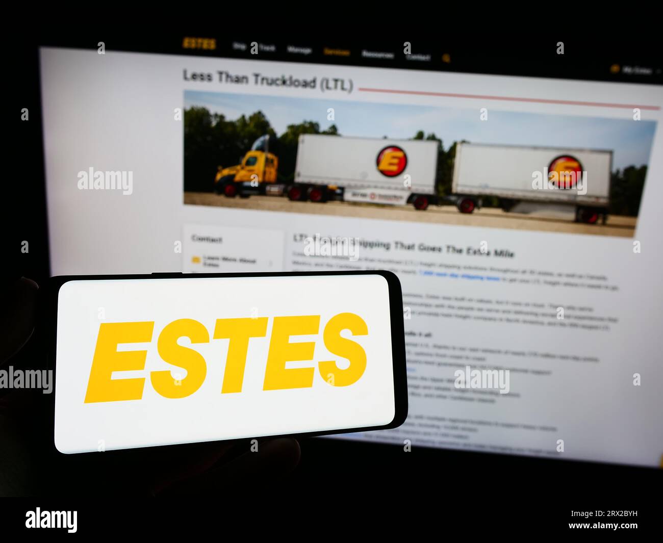Person holding smartphone with logo of US logistics company Estes Express Lines on screen in front of website. Focus on phone display. Stock Photo