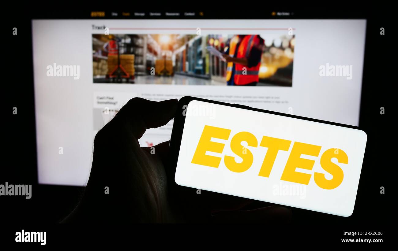 Person holding cellphone with logo of US logistics company Estes Express Lines on screen in front of business webpage. Focus on phone display. Stock Photo