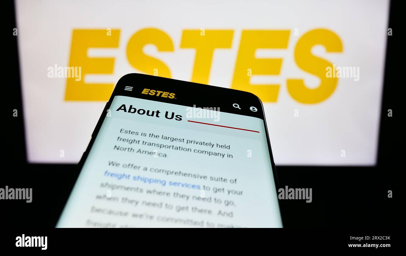 Smartphone with web page of US logistics company Estes Express Lines on screen in front of business logo. Focus on top-left of phone display. Stock Photo