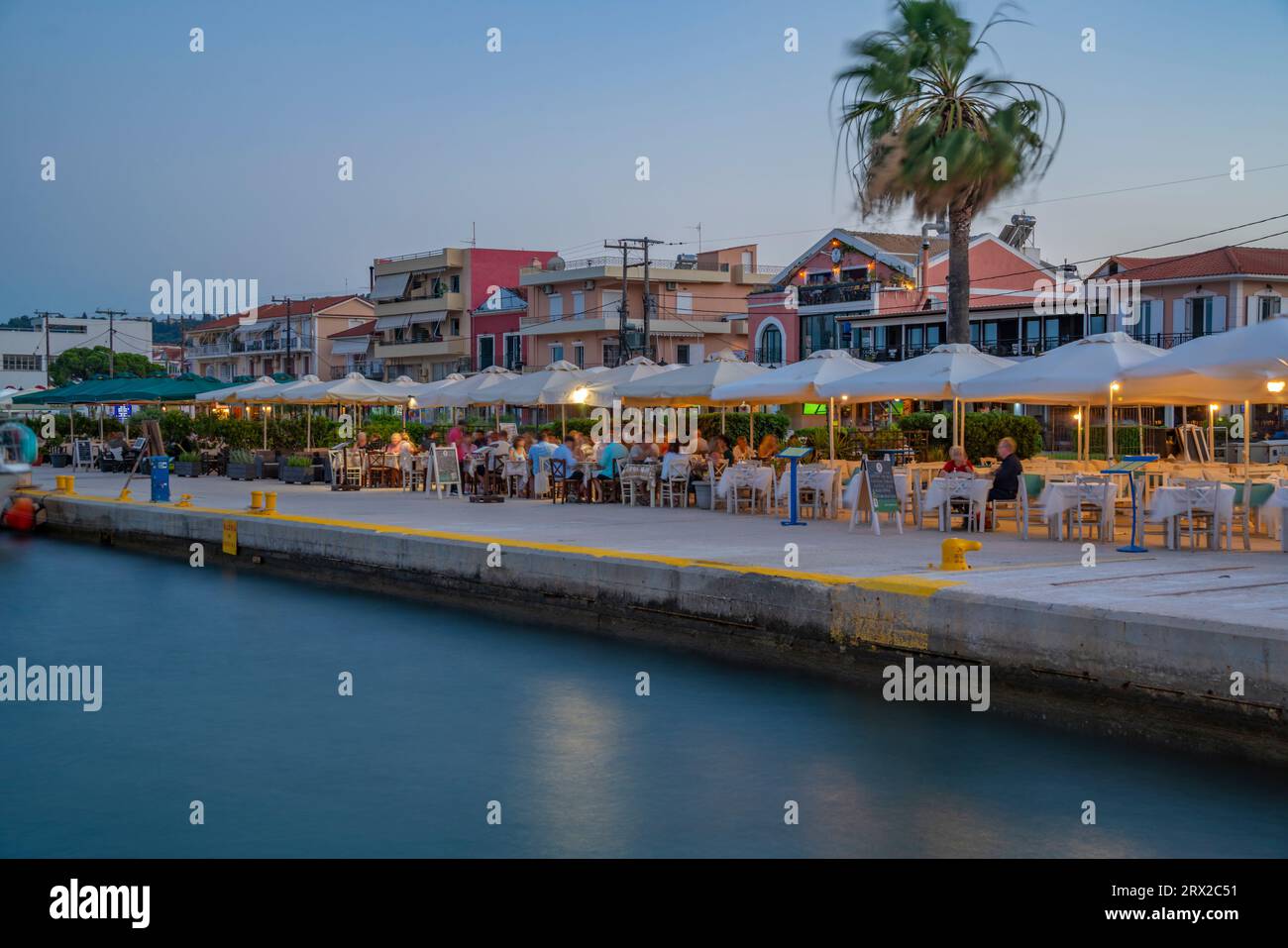 View of cafe and restaurant at the harbour at dusk, Lixouri, Kefalonia, Ionian Islands, Greek Islands, Greece, Europe Stock Photo