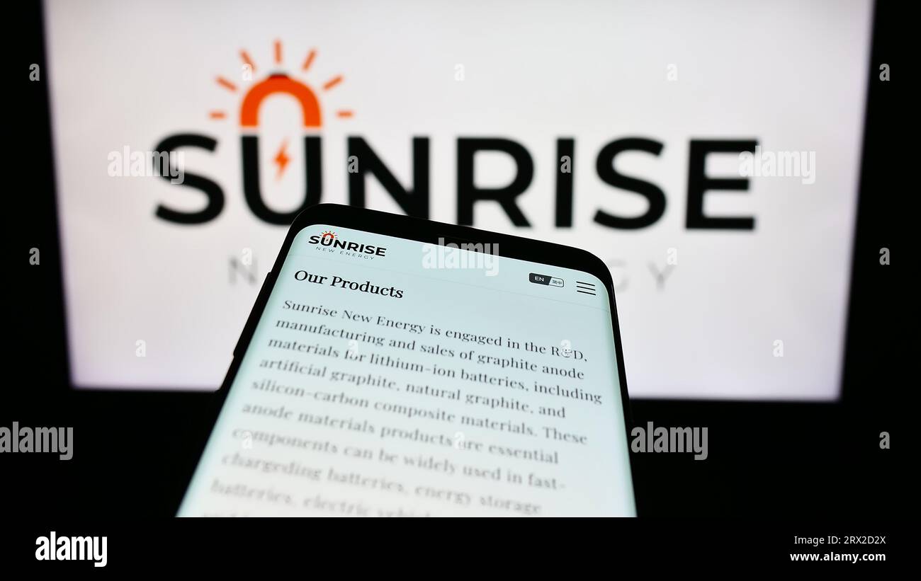 Mobile phone with website of Chinese company Sunrise New Energy Co. Ltd. on screen in front of business logo. Focus on top-left of phone display. Stock Photo