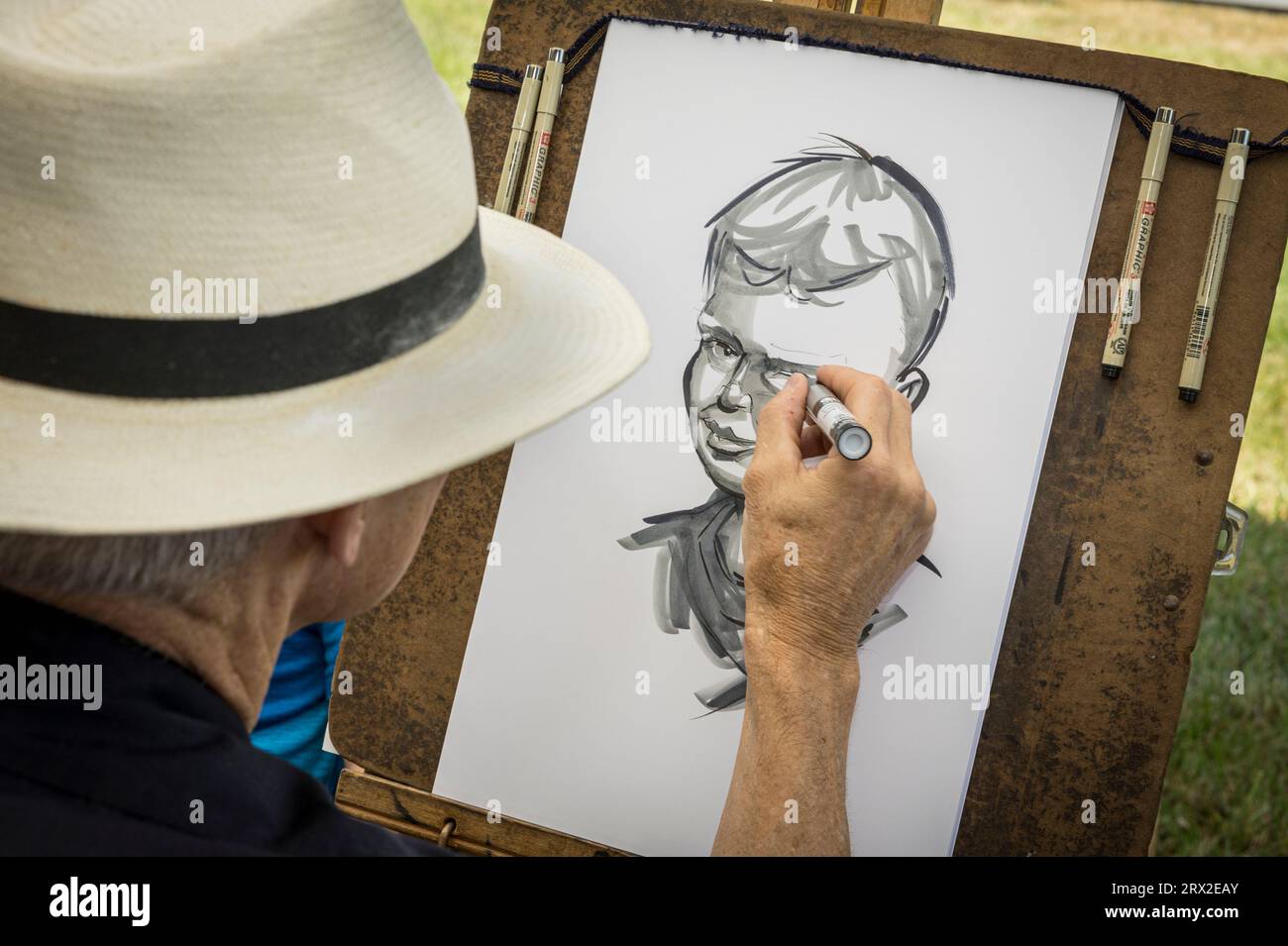 caricature artist drawing young boys caricature portrait, Maryland USA Stock Photo