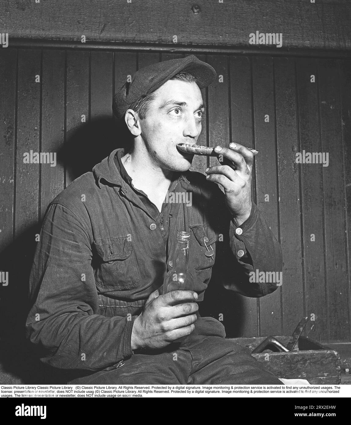 In the 1940s. It is lunch break and a man is eating a sandwich and has ...