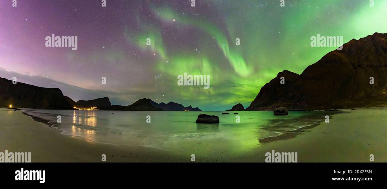 Panoramic of the frozen Haukland beach under a multicolored sky with ...