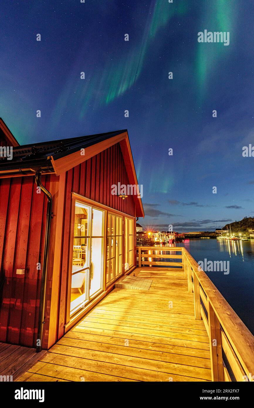 Illuminated red cabin under the Northern Lights, Hamnoy, Reine, Lofoten Islands, Nordland, Norway, Scandinavia, Europe Stock Photo