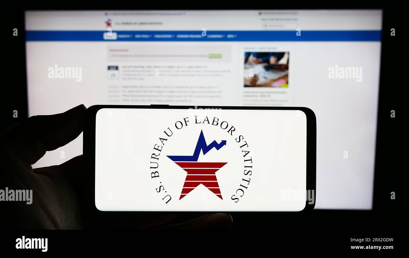Person holding mobile phone with logo of united states bureau of labor