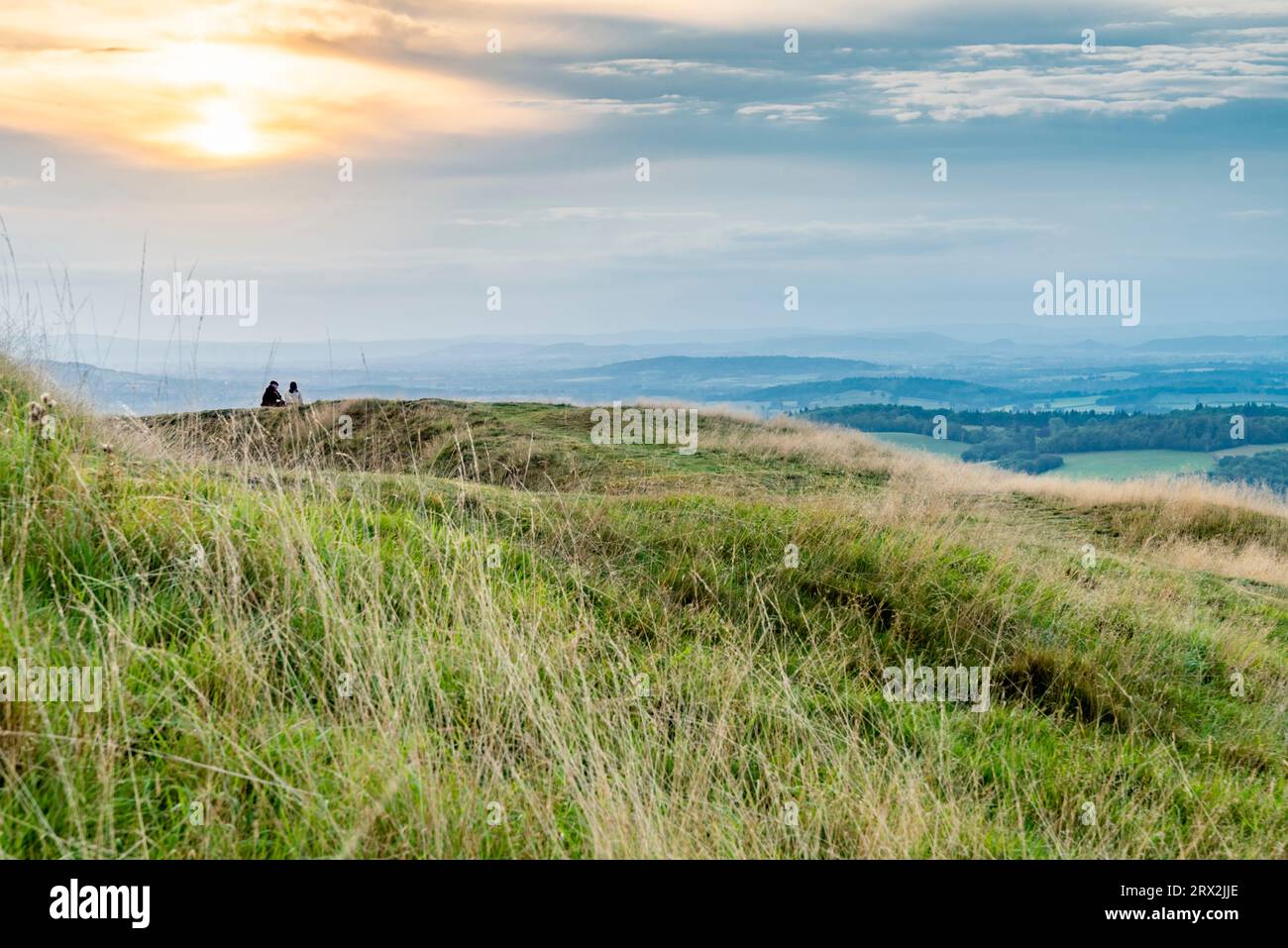 View from Pathway leading,down,from the summit of Herefordshire Beacon, the Iron Age hill fort,looking towards Wales and the setting sun. Stock Photo