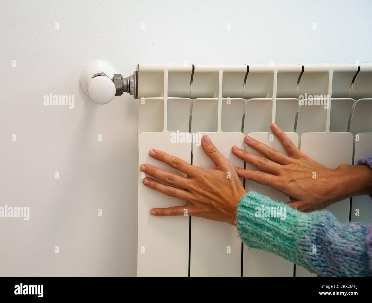 Temperature control on the apartment radiator. Hands in winter next to ...