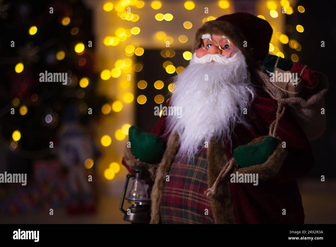 Santa Claus carrying big bag full of gifts, at home near Christmas Tree ...