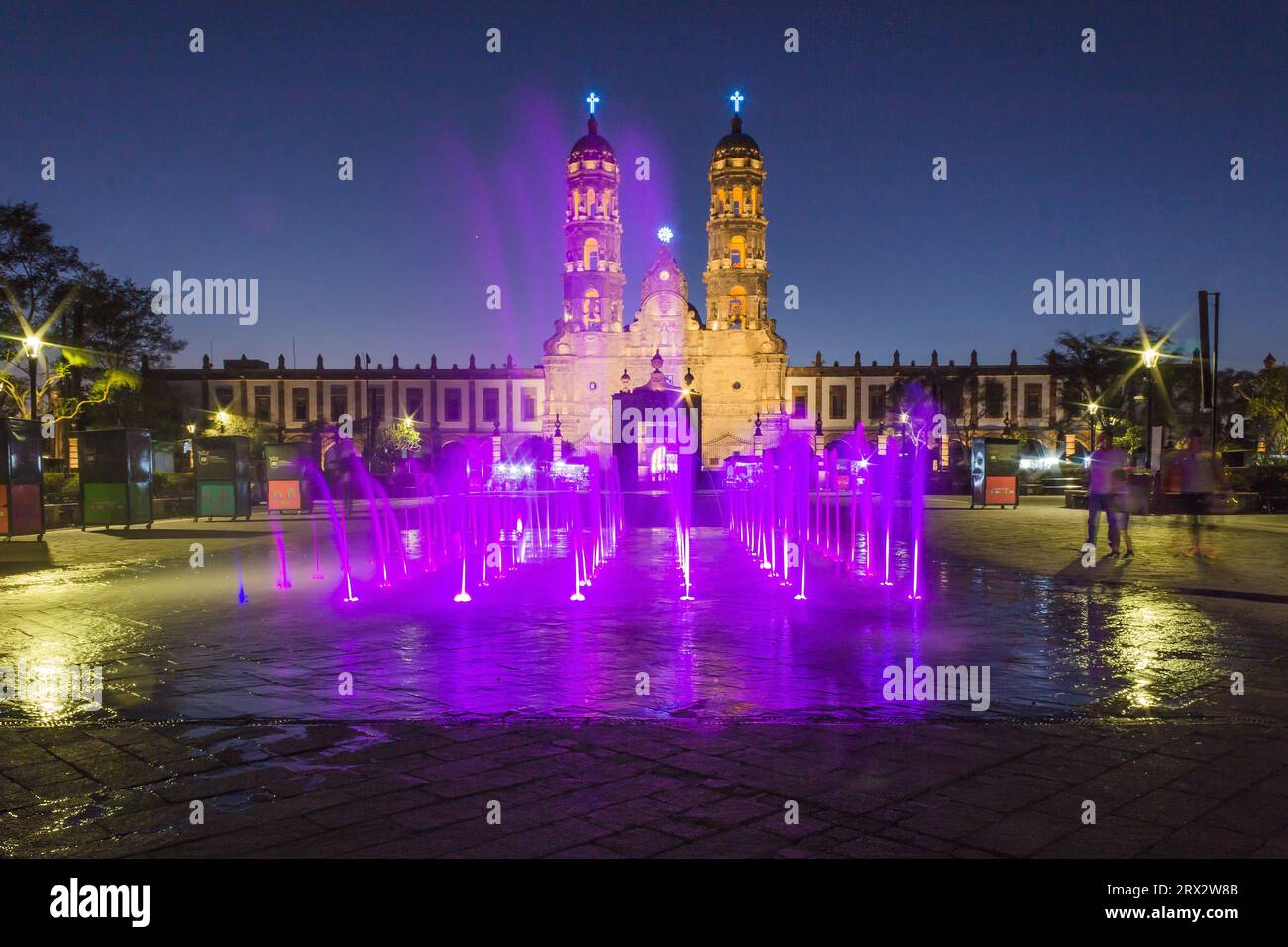 Zapopan Basilica, Guadalajara, Mexico, illuminated by spotlights at night and by coloured water fountains in the foreground. Stock Photo