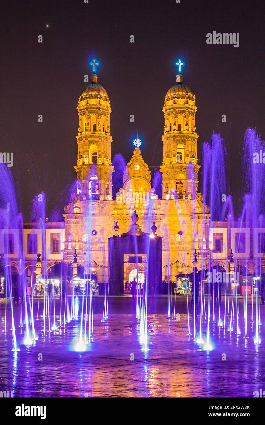 Zapopan Basilica, Guadalajara, Mexico, illuminated by spotlights at night and by coloured water fountains in the foreground. Stock Photo
