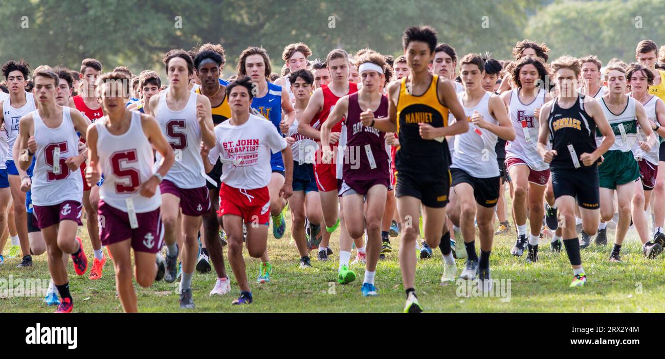 Kings Park, New York, USA - 15 September 2023: Front view of a large goup of high school boys running at the start of a 5K cross country race at Sunke Stock Photo