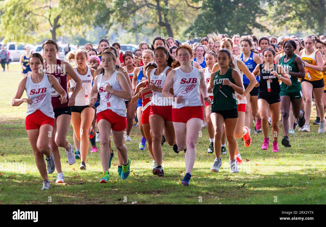 Kings Park, New York, USA - 15 September 2023: Front view of a large goup of high school gilrs running at the start of a 5K cross country race at Sunk Stock Photo