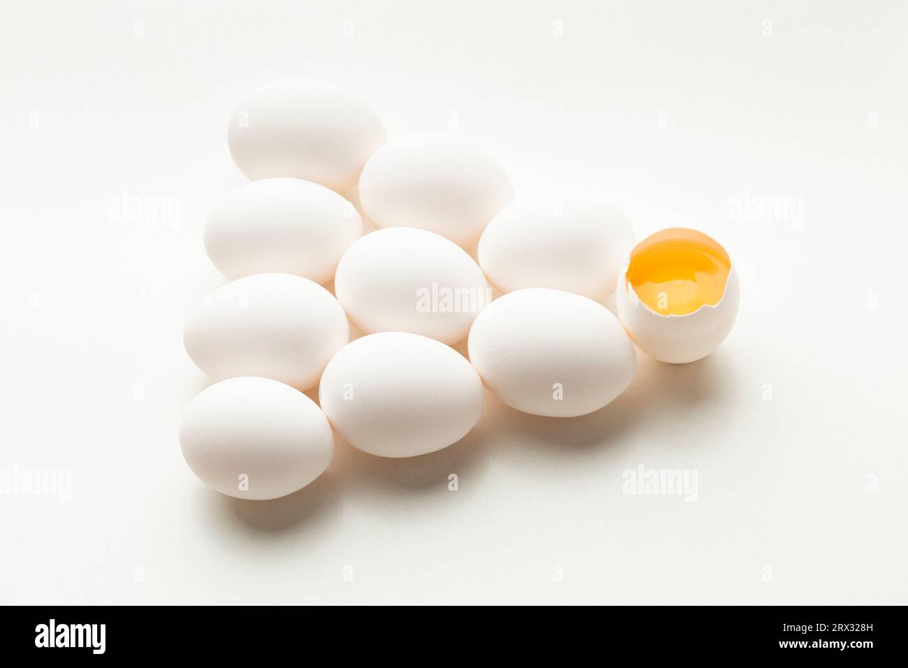 White eggs on a white background, one egg is broken, unlike the others. High quality photo Stock Photo