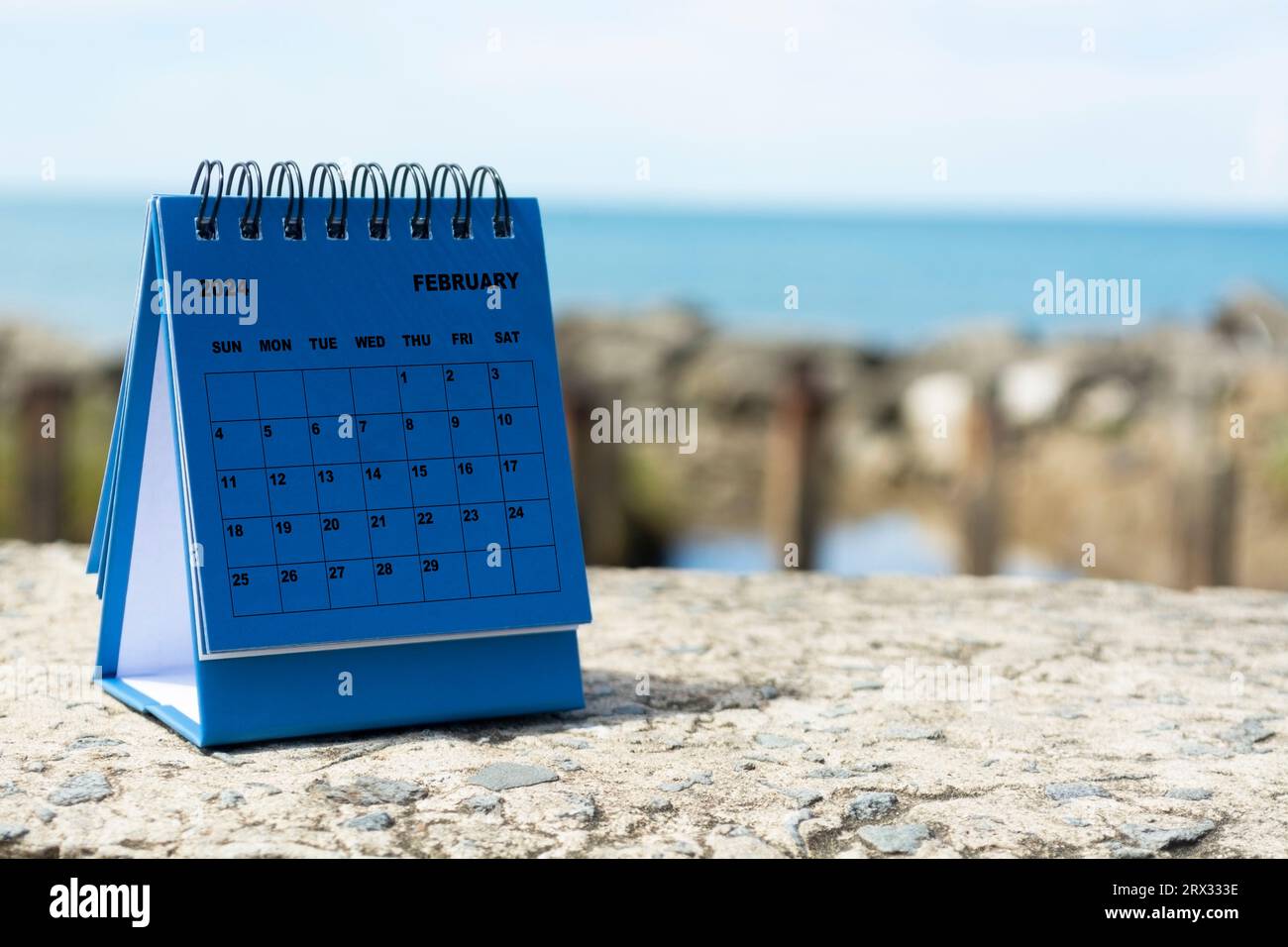 Blue February 2024 calendar on blurred background of blue ocean. 2024
