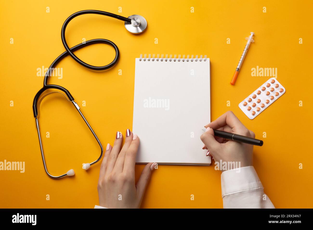Professional doctor writing medical records in a notebook with
